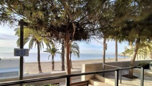 Ein Balkon mit Blick auf den Strand, Palmen und einen klaren Himmel.