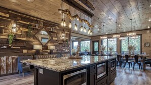 Una cocina amplia con una isla grande, paredes de madera e iluminación moderna.