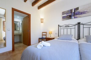 Hotelkamer met een bed, een stoel, een nachtkastje, een lamp en een schilderij aan de muur.