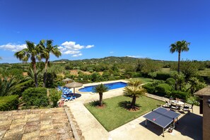 A pool area with a table tennis table, palm trees, and a clear blue sky. - Teuler Petit for 8 people, magnificent outdoor area, beautiful rural setting (Cas Concos des Cavaller)