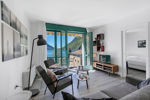 Ett modernt vardagsrum med en soffa, fÄtölj, soffbord och ett TV-bord.