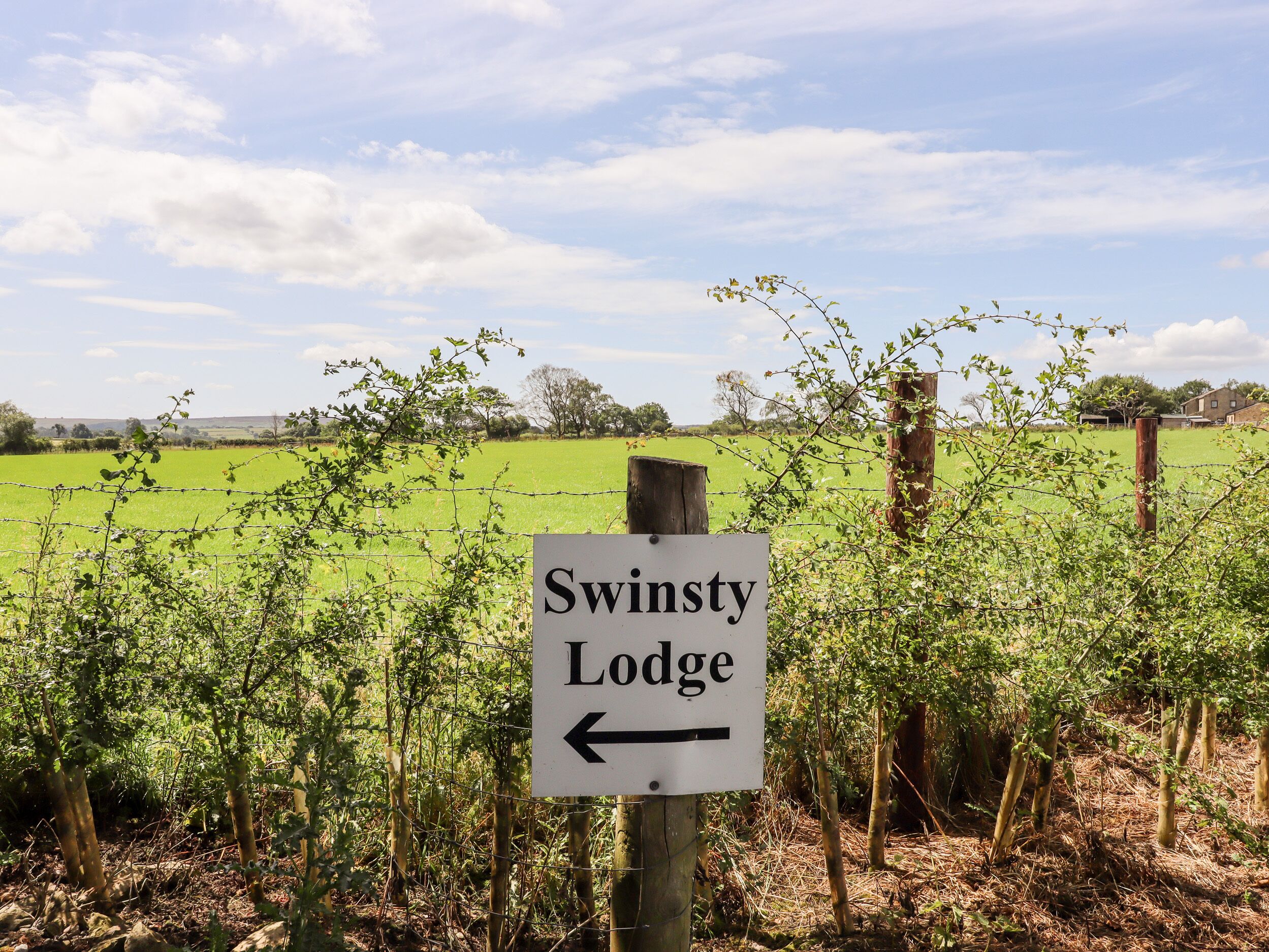 A sign for Swinsty Lodge with an arrow pointing left.