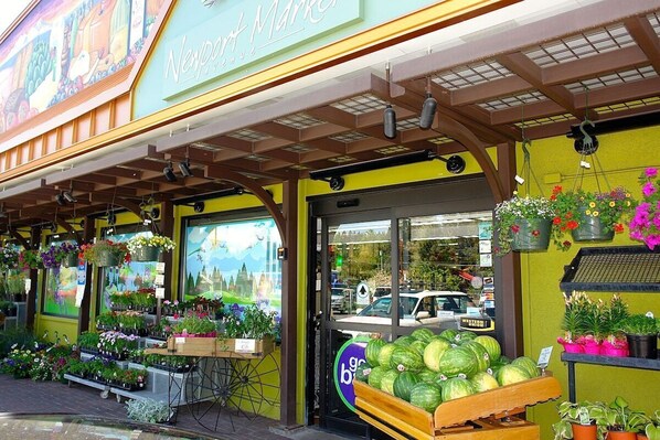 Une devanture de magasin où sont exposées, à l’extérieur, diverses plantes et fleurs.