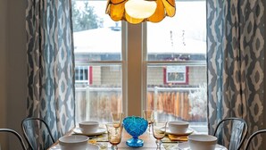 A dining table set with white bowls and glasses, a blue decorative bowl, and a patterned table runner. - Bluebird Day - Desert Moon, Cozy 2BR in Bend's River West, Walkable to restaurants! (Bend)