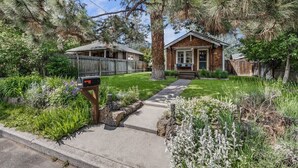 A residential property with a well-maintained lawn, a mailbox, and a wooden fence. - Bluebird Day - Desert Moon, Cozy 2BR in Bend's River West, Walkable to restaurants! (Bend)