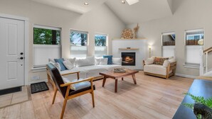A spacious living room with a fireplace, a sofa set, a coffee table, and a wooden chair. - Bluebird Day - Hartford Haven, a spacious 3BR home with modern amenities. (Bend)
