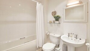 A modern bathroom with a bathtub, toilet, and sink. - Host & Stay | Harbour View (Whitby)