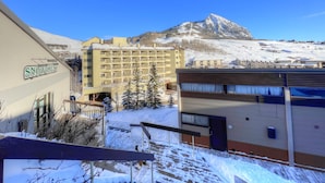 A hotel named Snowcrest with a mountain view, a multi-story building, and a snow-covered landscape.