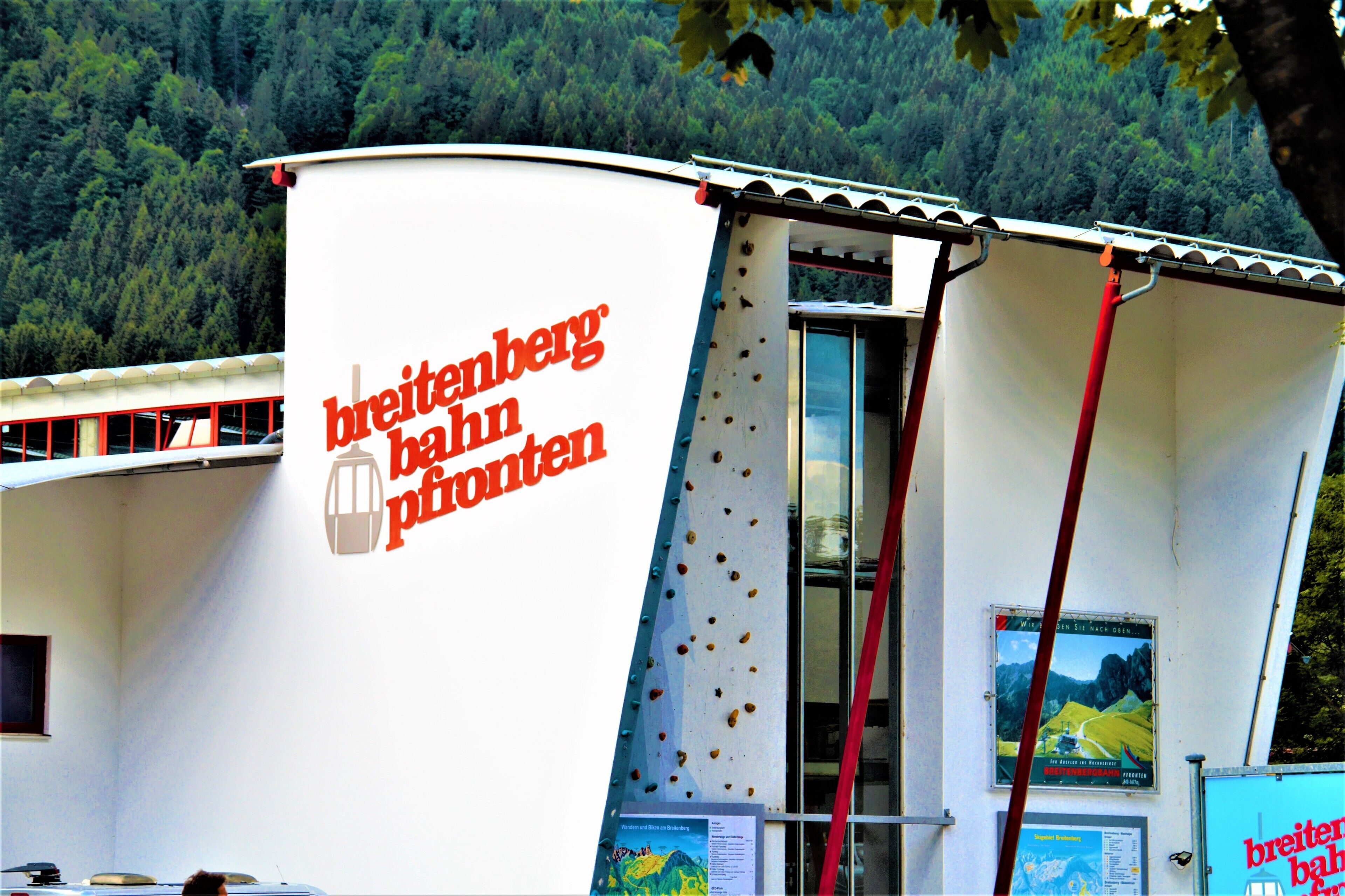 A building with a sign reading "breitenberg bad pfoten" and a poster of a mountain landscape.