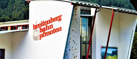 A building with a sign reading "breitenberg bad pfoten" and a poster of a mountain landscape.