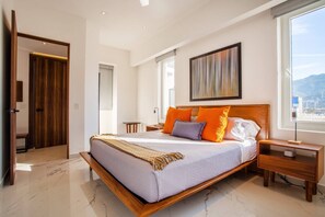 A modern bedroom with a large bed, wooden headboard, and a city view.