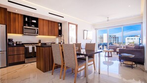 A modern kitchen with a built-in microwave, wooden cabinets, and a dining area with chairs.