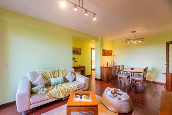 Un salon comprenant un canapé, une table basse et un coin repas avec une table et des chaises.