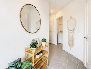 A hallway with a wooden bench, a round mirror, and a dreamcatcher on the wall. - Fairy Tale Disney Stay / Garage Access / Water Fun (Four Corners)