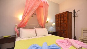 A bedroom with a bed, a nightstand, a wooden wardrobe, and a floor lamp. - Apartment with Terrace (Yianna Cottage Studios) (Skopelos)