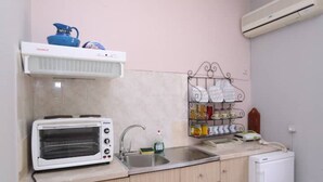 A compact kitchen with a built-in microwave, a toaster, a sink, and a small refrigerator. - Apartment with Terrace (Yianna Cottage Studios) (Skopelos)