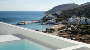 Une piscine offrant une vue dégagée sur la mer et un village côtier.