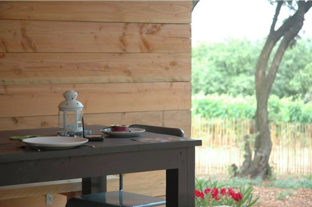 A wooden table with a lantern, plates, and cutlery.