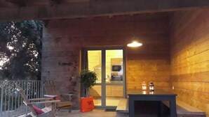 Une cabane en bois avec un balcon, une table et des chaises.