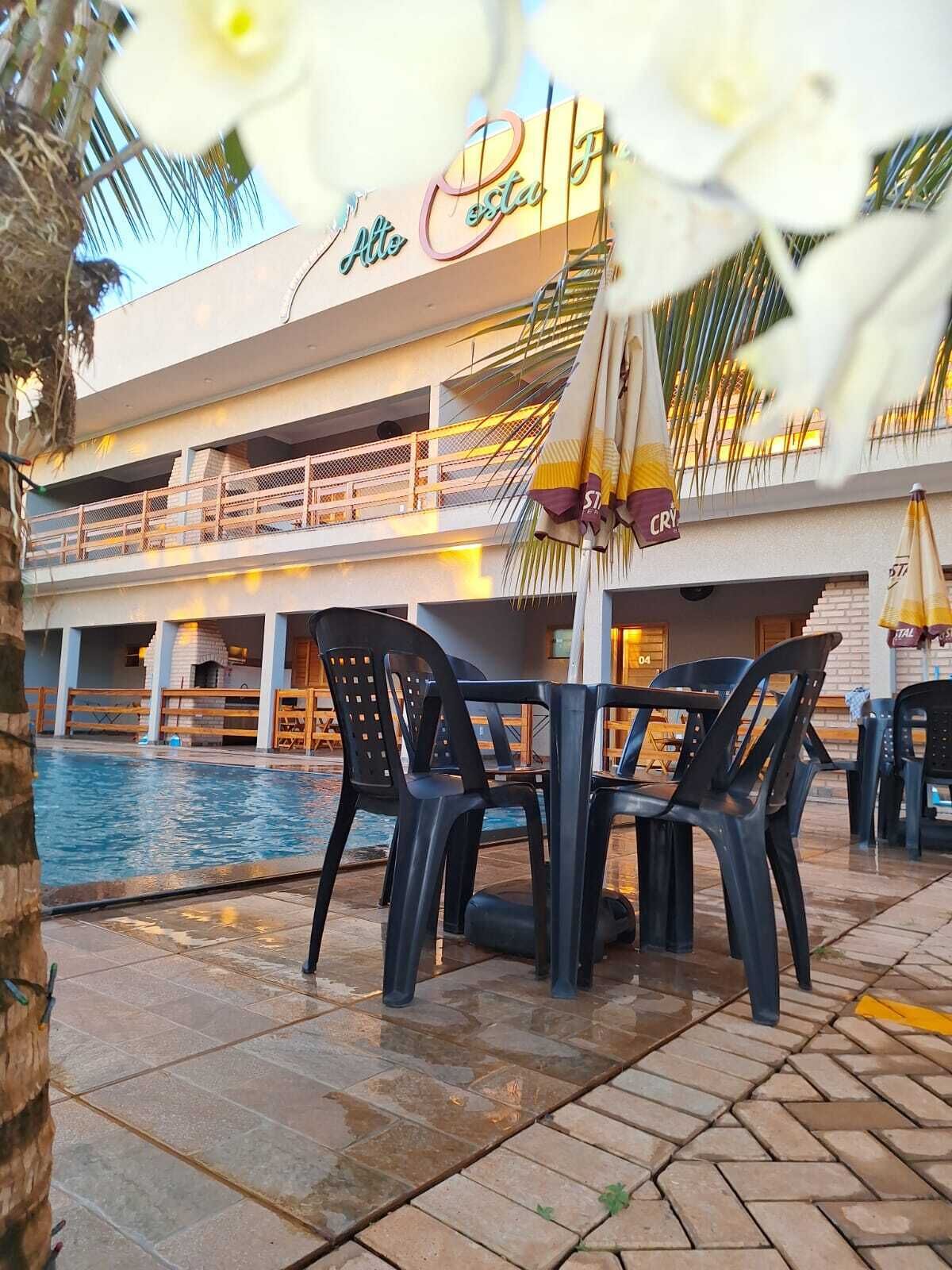 A poolside area with outdoor seating and a building with balconies.