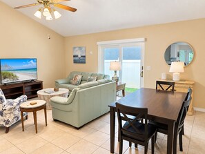 A living room with a sofa, TV, and dining area.
