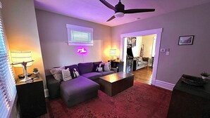A living room with a sofa, ottoman, coffee table, and a ceiling fan. - Newly Updated: Nearby Short North / OSU! (Columbus)