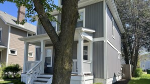 A two-story residential building with a front porch, a brick chimney, and a well-maintained lawn. - Newly Updated: Nearby Short North / OSU! (Columbus)