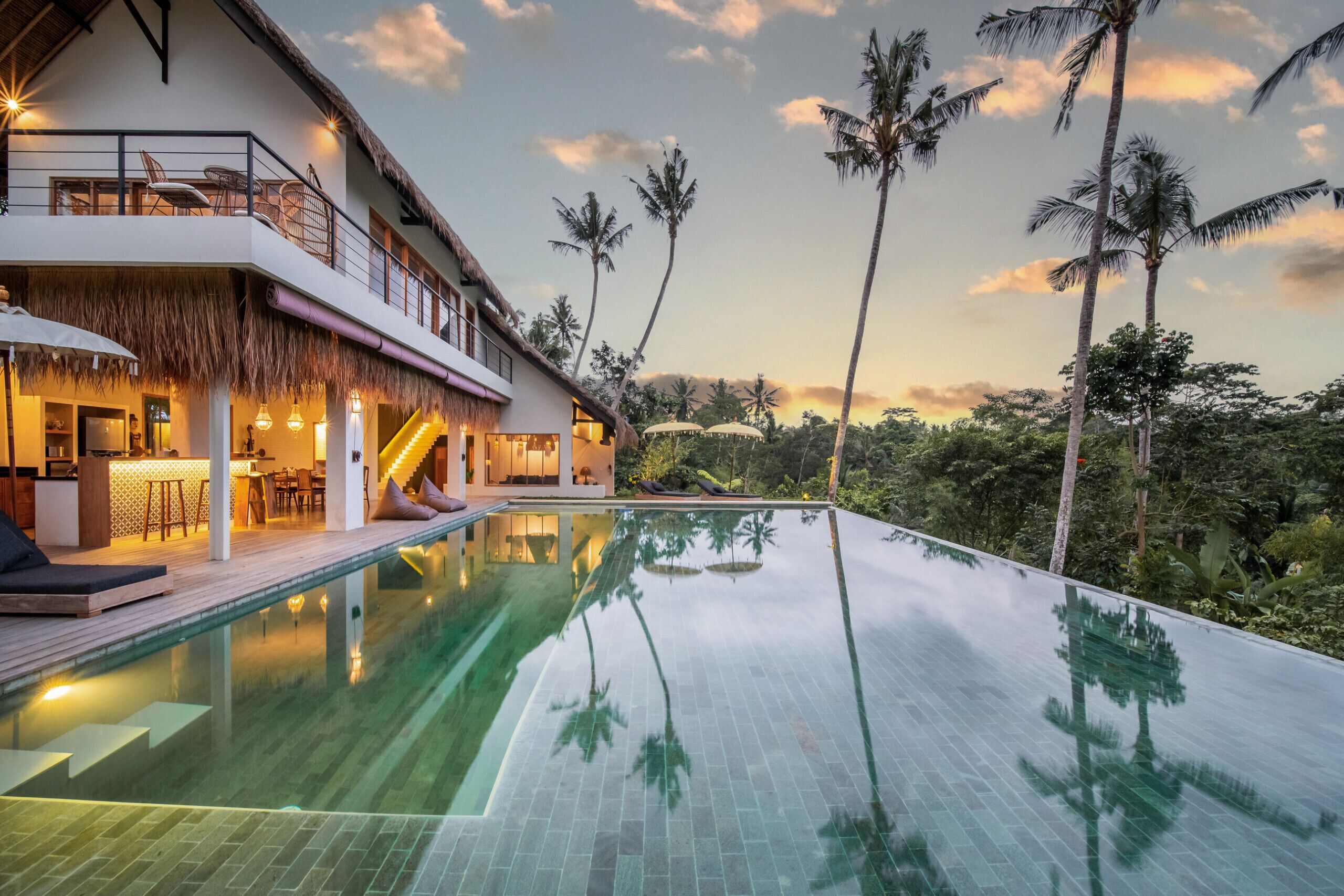 A modern resort with a large infinity pool, a bar area, and a dining space.