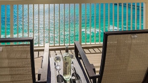 Ein Balkon mit Blick auf türkisfarbenes Wasser und einen entfernten Steg.