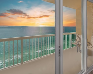 Ein Balkon mit Blick auf den Ozean bei Sonnenuntergang.