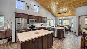 A spacious kitchen with dark wooden cabinets, stainless steel appliances, and a large island.