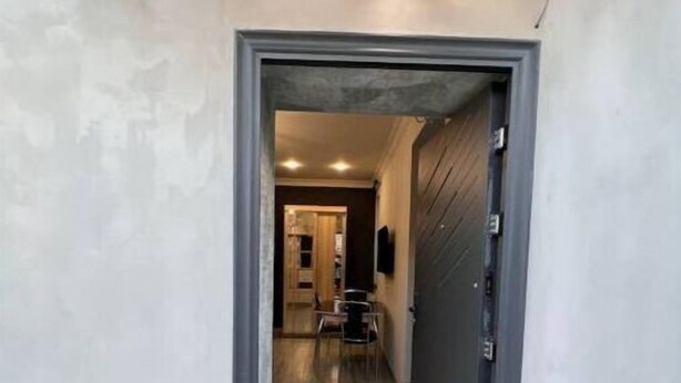 A hallway with a dark door, a light fixture above, and a tiled floor. - House in Antarayin, Yerevan, Armenia (Yerevan)