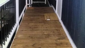A wooden deck leading to a building with white railings and windows. - Silver pine one bedroom with a nice patio deck. (Austin)