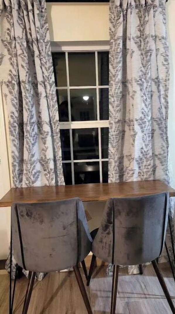 A dining area with a wooden table and two grey chairs. - Silver pine one bedroom with a nice patio deck. (Austin)