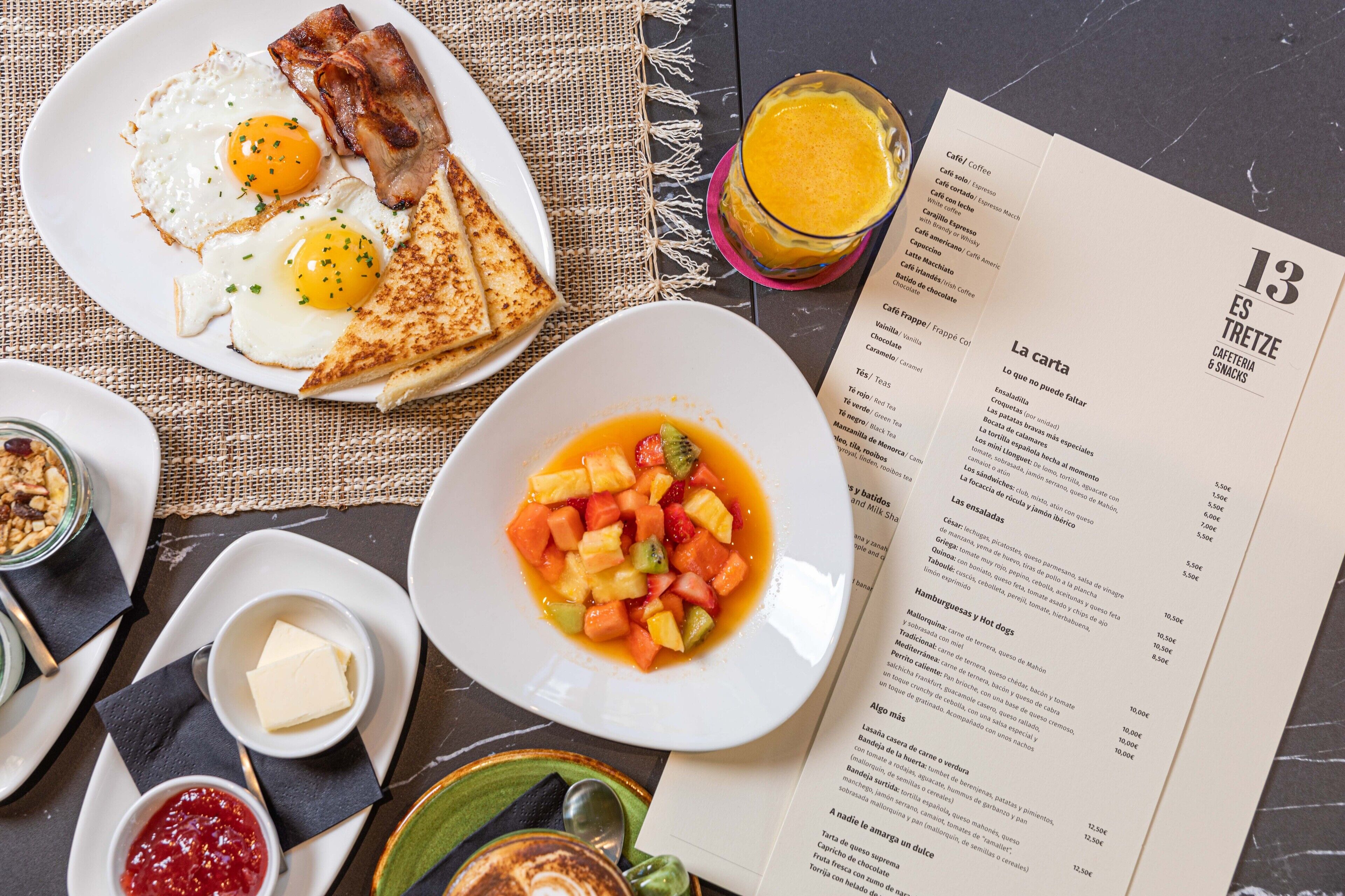 A breakfast setting with a menu, including toast, eggs, and a fruit bowl.