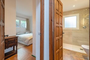 Une chambre à coucher avec un lit, une table de chevet et une fenêtre.