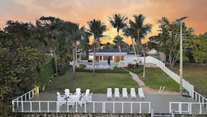 A resort with a pool area, lounge chairs, and a deck overlooking the pool. - Waterfront! Boat Dock and Guesthouse (North Palm Beach)