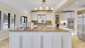 A spacious kitchen with white cabinetry, a granite countertop, and stainless steel appliances. - Waterfront! Boat Dock and Guesthouse (North Palm Beach)
