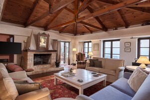 Una sala de estar acogedora con chimenea de piedra, vigas de madera en el techo y asientos cómodos.