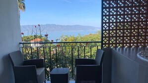 A balcony with wicker furniture, a view of the sea, and a decorative lattice. - Casa Rivera de Moras (Tuxcueca)