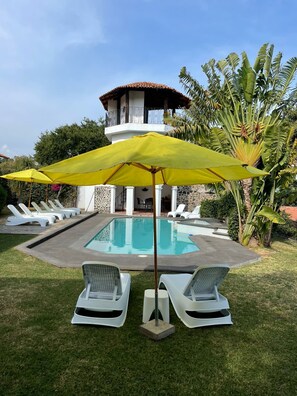 A swimming pool with lounge chairs and a yellow umbrella. - Casa Rivera de Moras (Tuxcueca)