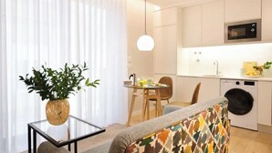 Una cocina moderna equipada con microondas, lavadora y zona de comedor con mesa y sillas.