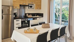 Una cocina moderna con una mesa de comedor, sillas y vistas al exterior.