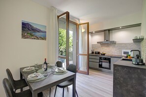 A modern kitchen with an island, dining table, and chairs.