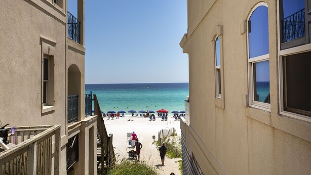 Vue d’une plage depuis un immeuble doté de balcons donnant sur la mer.
