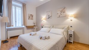 Quarto bem arrumado com uma cama grande, abajures e obras de arte nas paredes.