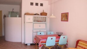 A compact living space with a kitchenette, a dining area with a table and chairs, and a small sofa. - ARRUBIU - small but comfy, perfect for singles, couples w. small children (P3399 (Cabras)