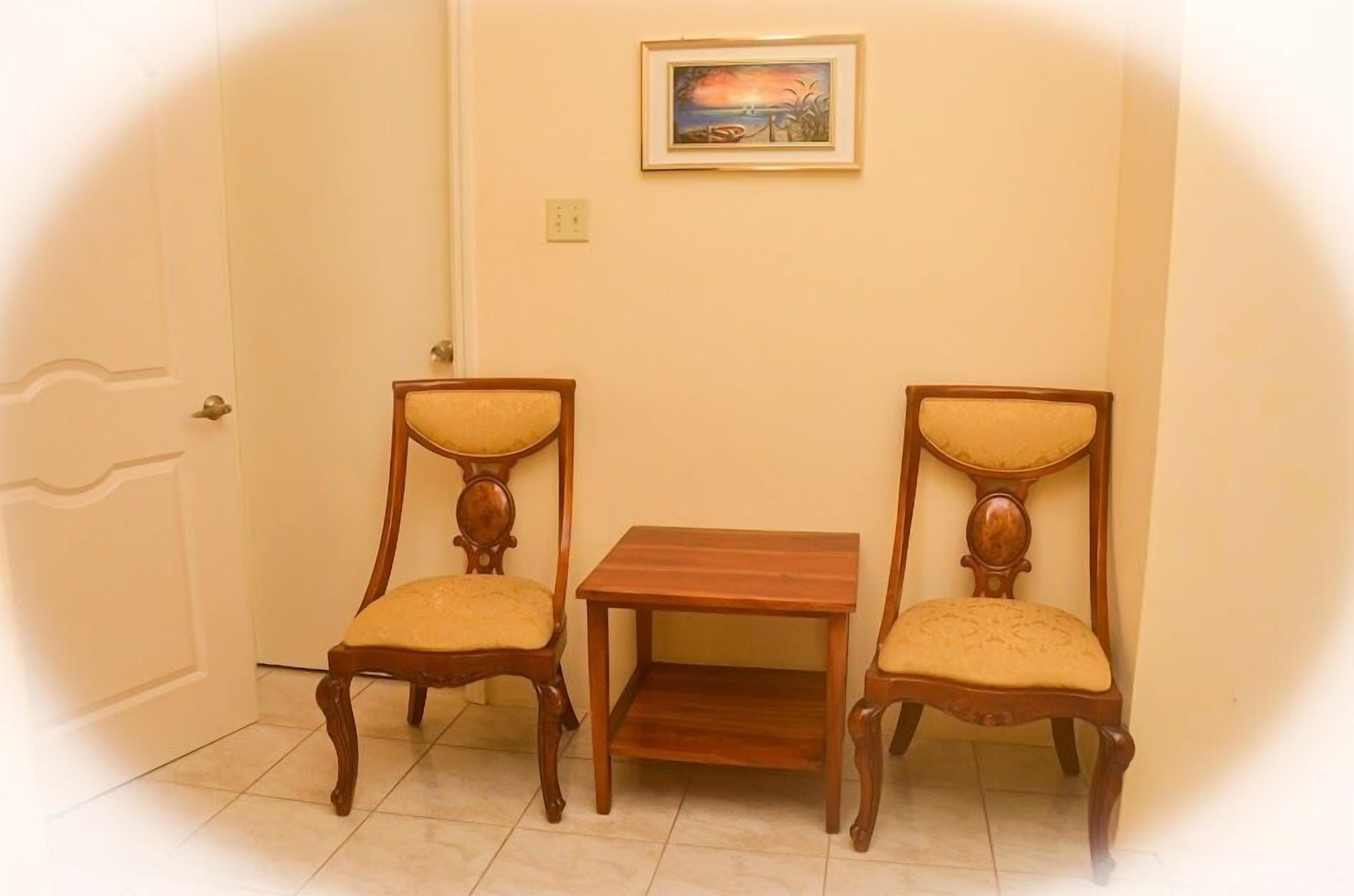 Une pièce avec deux chaises en bois et une petite table en bois.