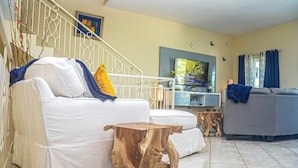 A living room with a white sofa, a wooden coffee table, and a grey sofa. - The Shallhome  (Montego Bay)