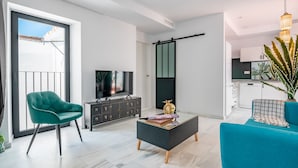 A modern living room with a teal armchair, a black coffee table, and a television. - Dreams of Marbella (Marbella)